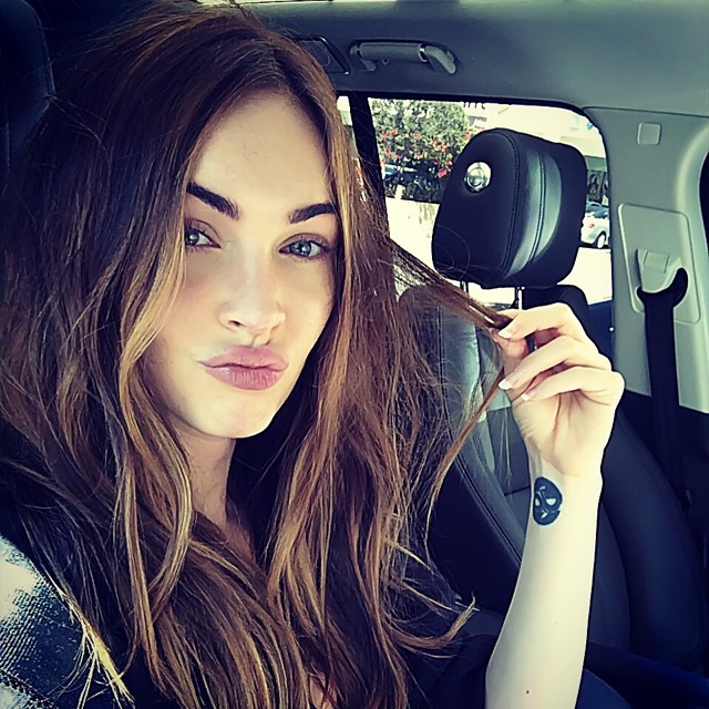 Gorgeous Megan Fox in a car playing with her hair Hot Image